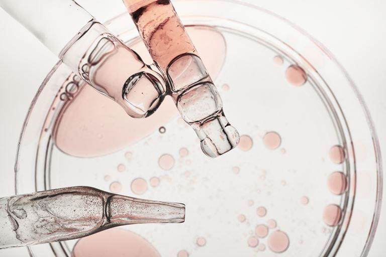 Liquid serum droplets and pipettes showing scientific lab procedure